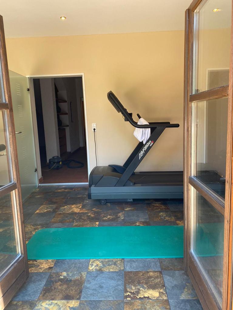 Fitnessraum mit Laufband und Yogamatte