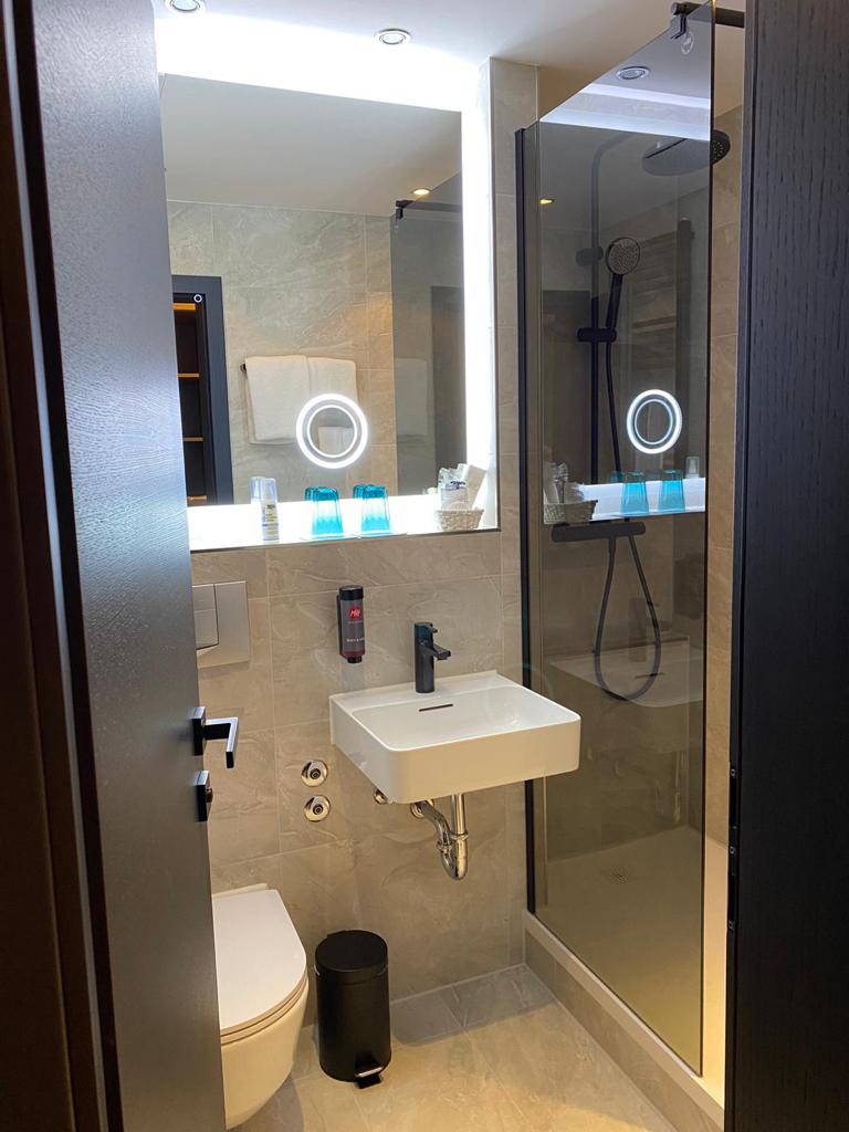Modernes Badezimmer mit Regendusche und Spiegel